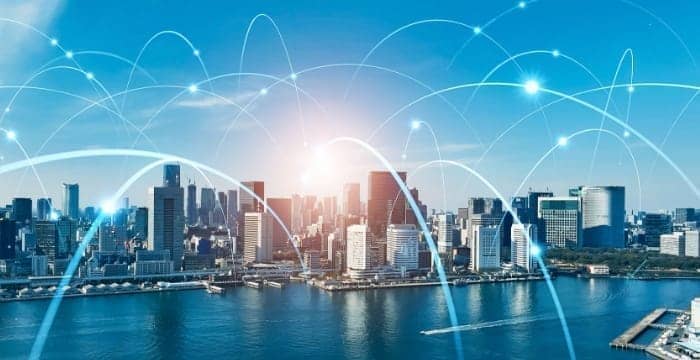 都市上空に広がるネットワーク接続を表す光の線のイメージ