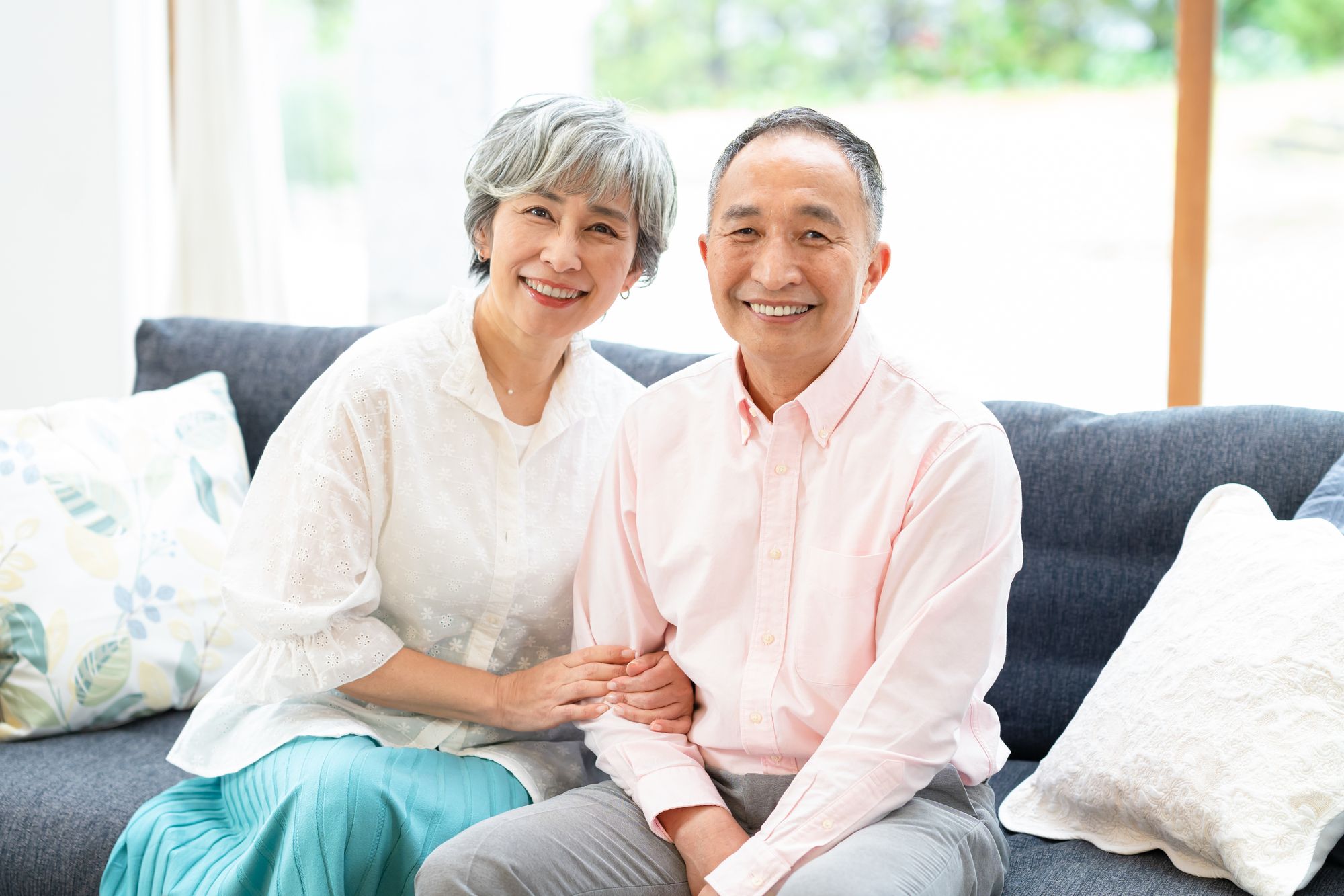 明るいリビングで寄り添って過ごすシニア夫婦